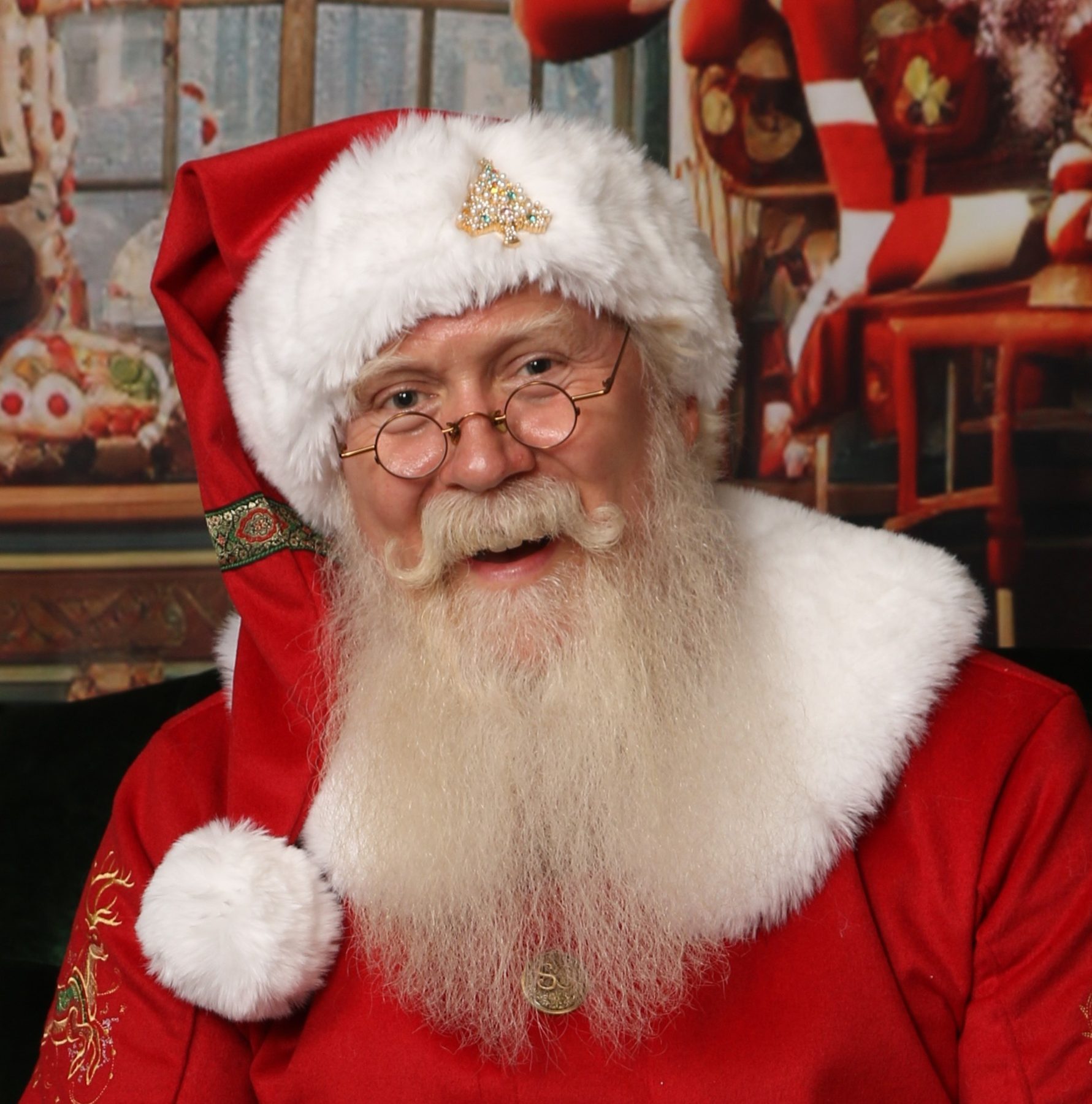 Santa Pat smiling warmly in his classic red suit and fur-trimmed hat