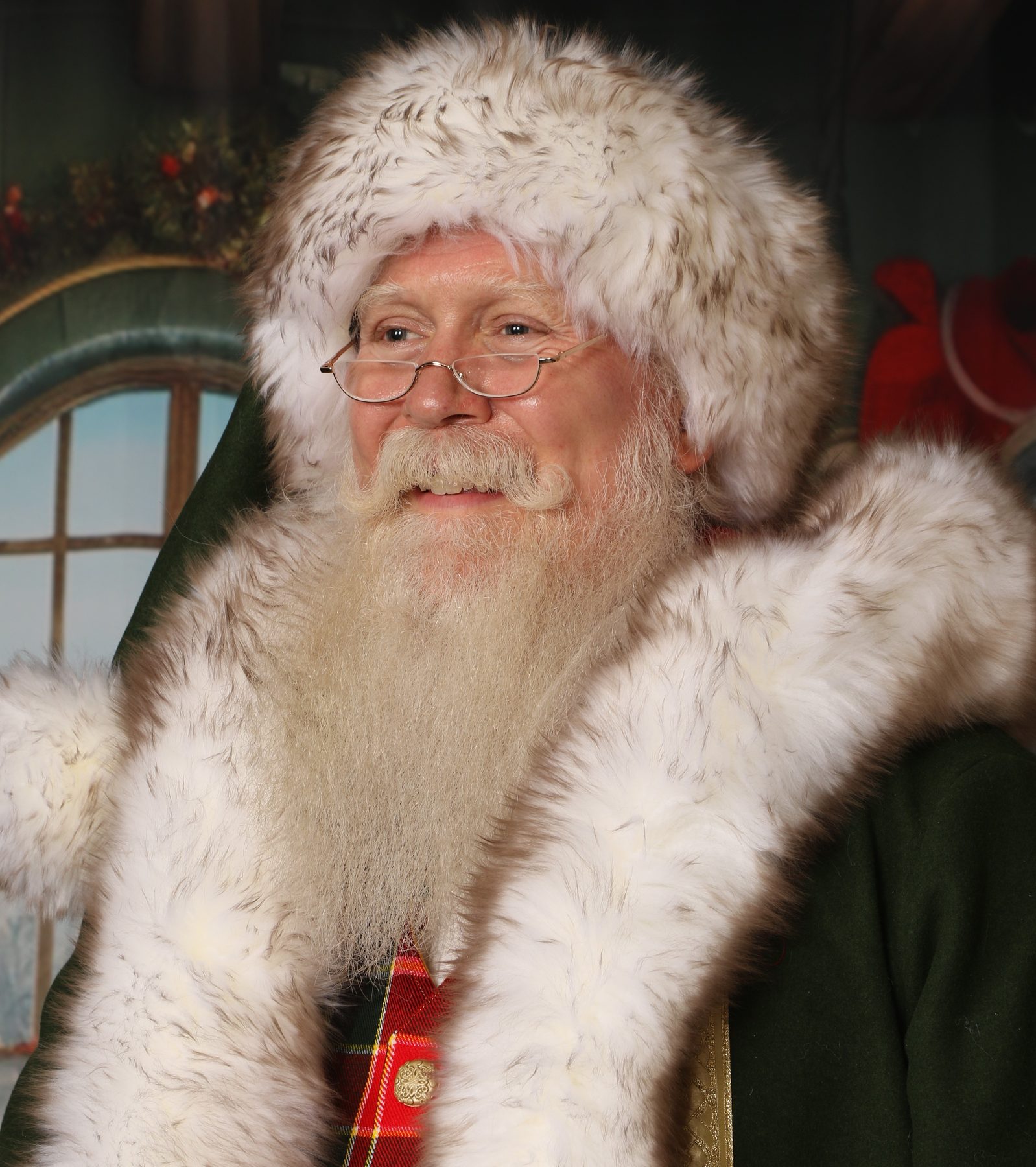 Santa Pat waving warmly, wearing his traditional white fur-trimmed coat and hat